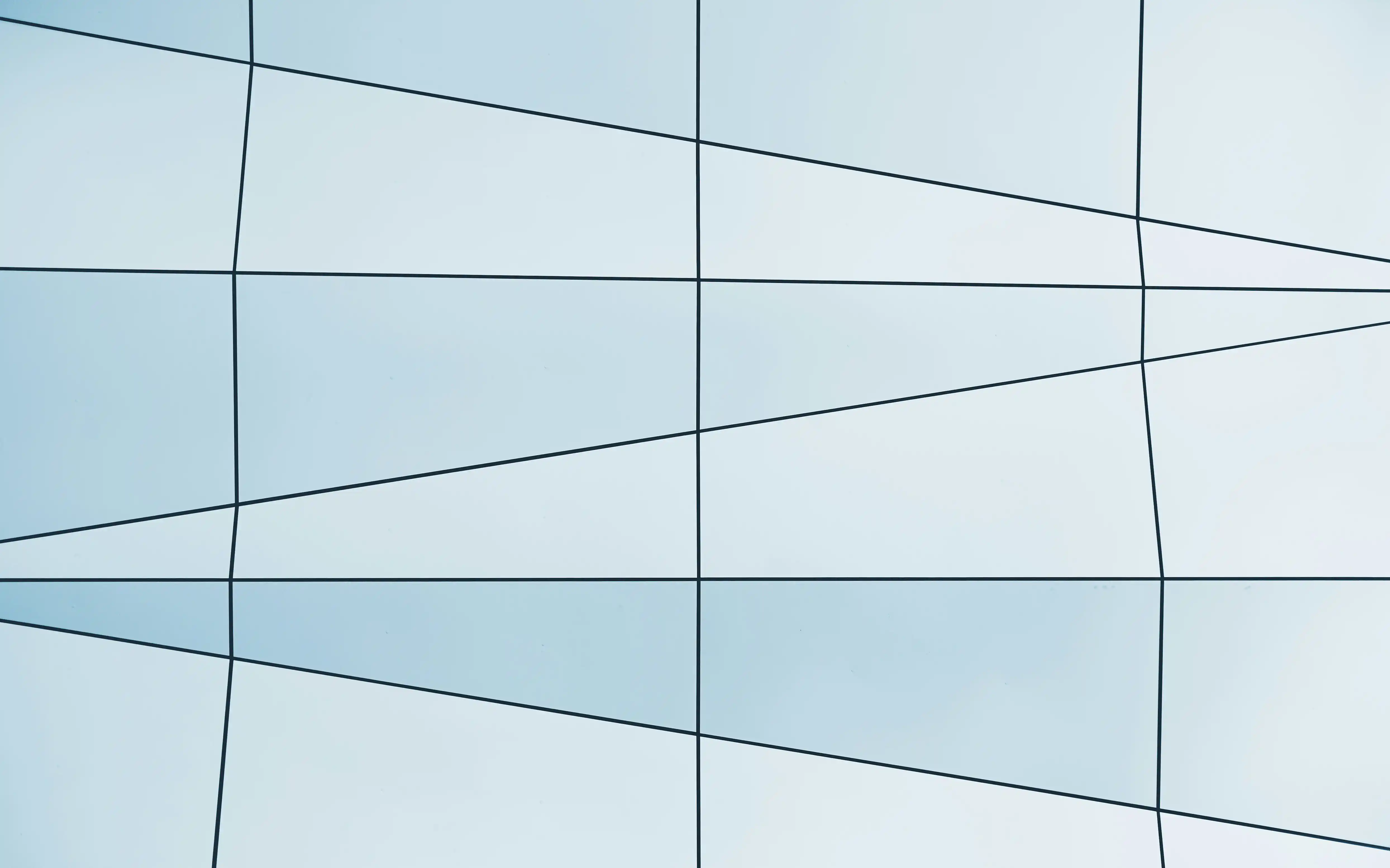 Close-up of modern curved glass building facade with black geometric framing.